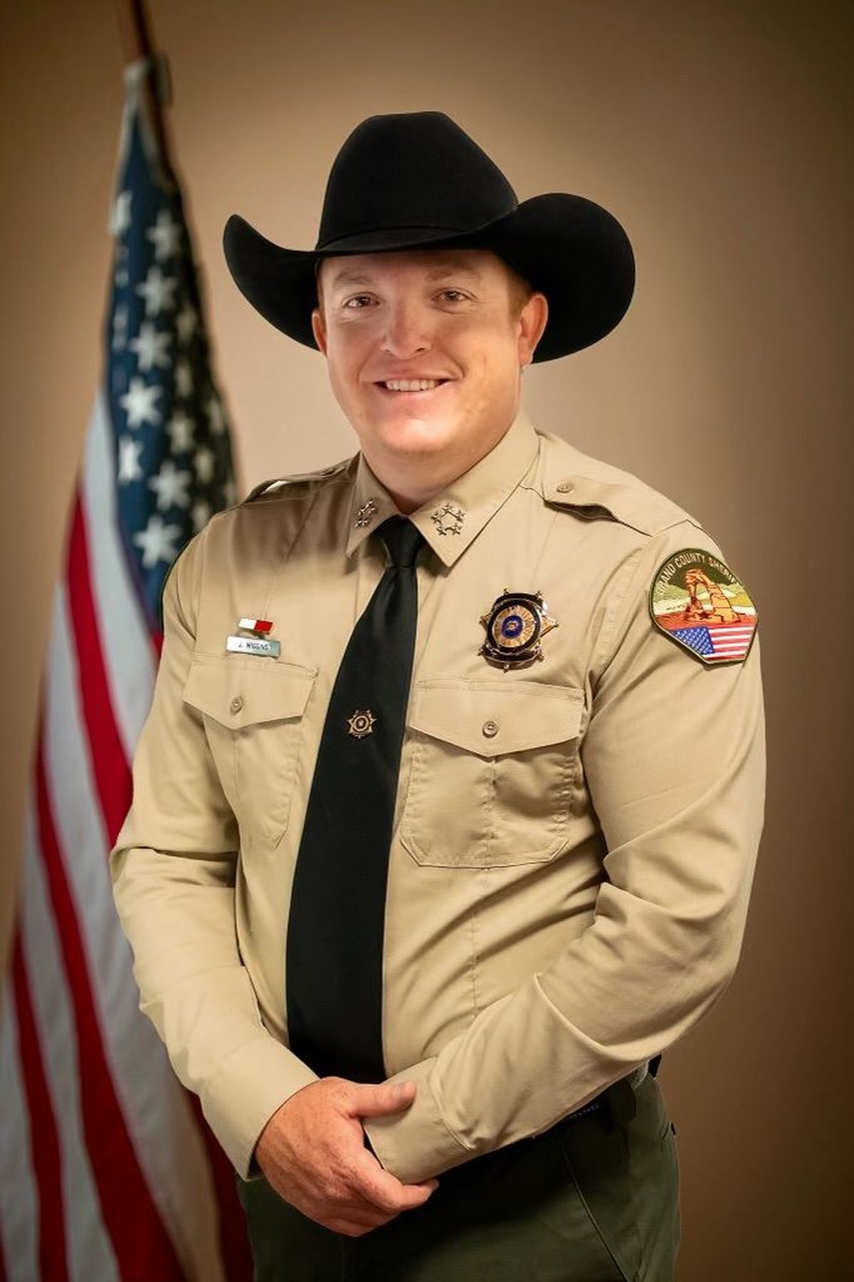 Sheriff Jamison Wiggins of Grand County, Utah in uniform beside the American flag